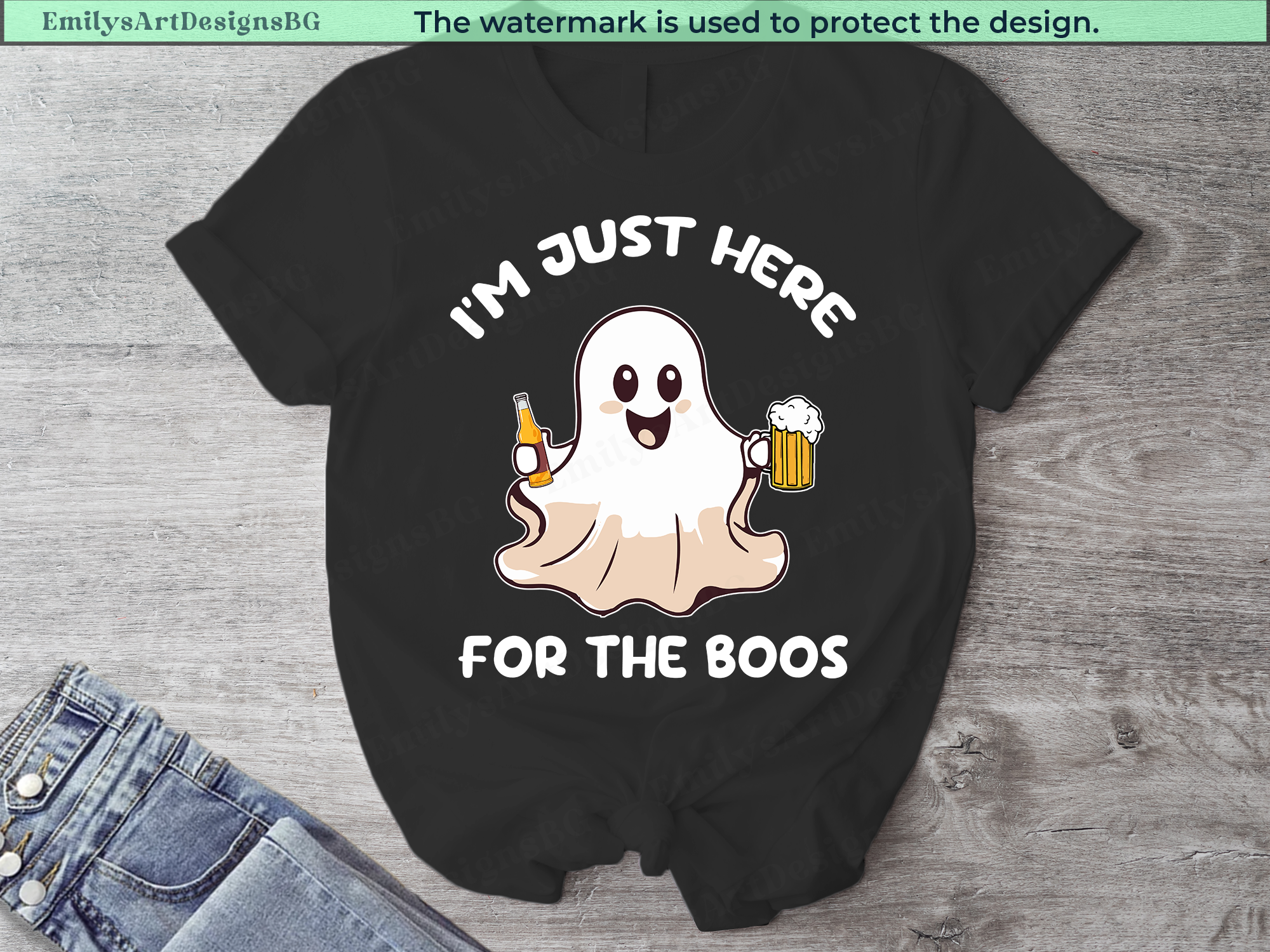 Black t-shirt with ghost graphic and text 'I'm just here for the boos' on a wooden surface.